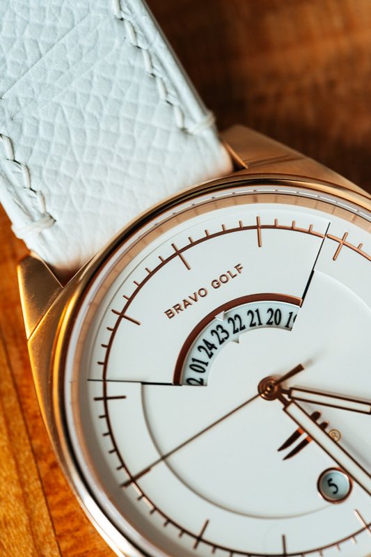 Close on The Katharine: white dial with the crescent GMT window, rose-gold-tone case, white leather strap.