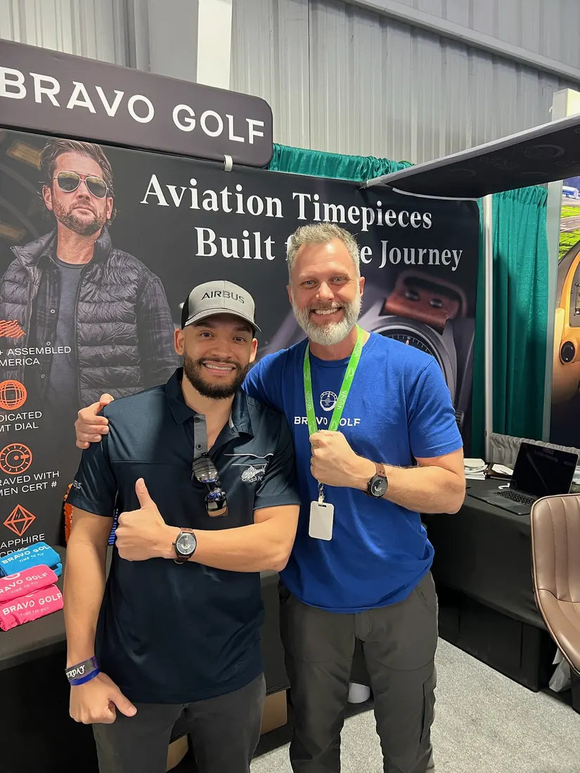 Beau and an adult pilot wearing their watches at an early Bravo Golf airshow booth