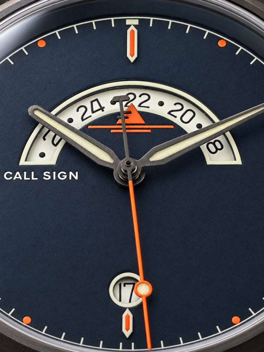 Macro of the Discovery 38 Classic dial: crescent GMT window at 12, orange seconds hand, luminous hands and markers, date at six.