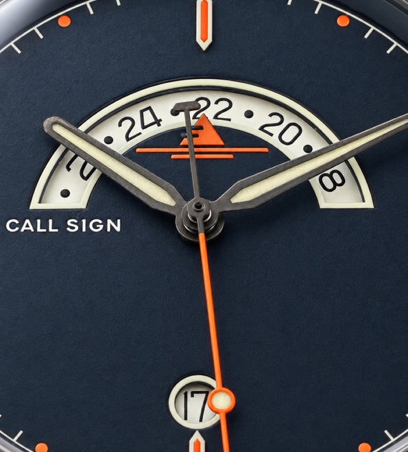 Close-up of the Classic dial: crescent GMT window, orange seconds hand, luminous hands and markers.