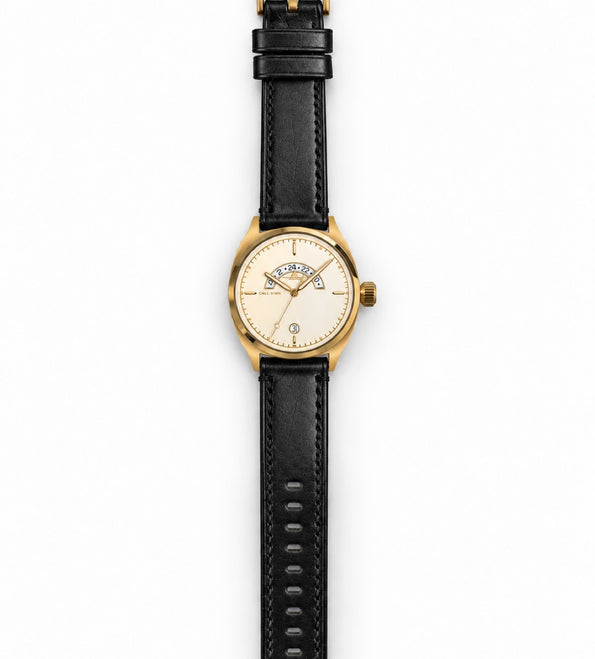 The Discovery 38 Gold laid out full length on its black leather strap.