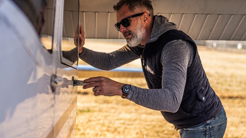 A pilot checks the wing of a Cessna, the Discovery on his wrist.