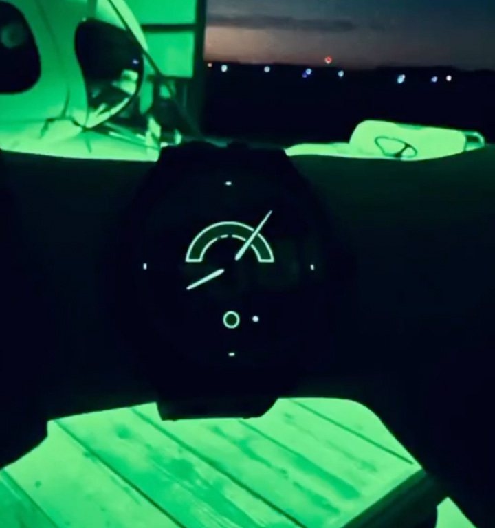 A Discovery dial glowing green in the dark.