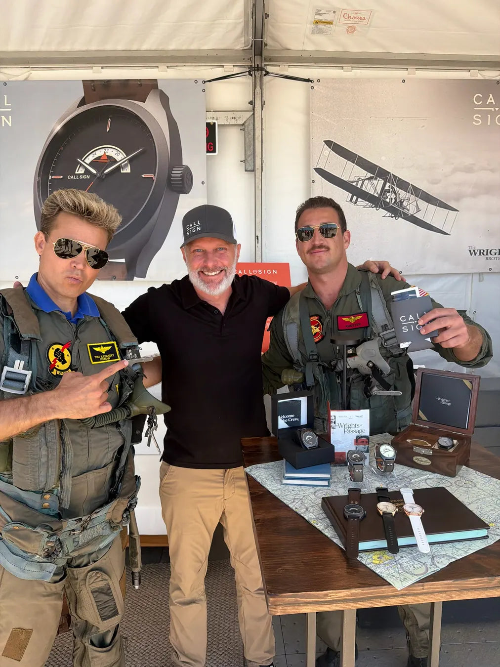 Beau with two adult aviators at the Call Sign booth, watches displayed on the table